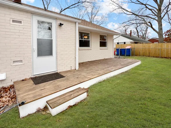 a front view of a house with a garden and trees