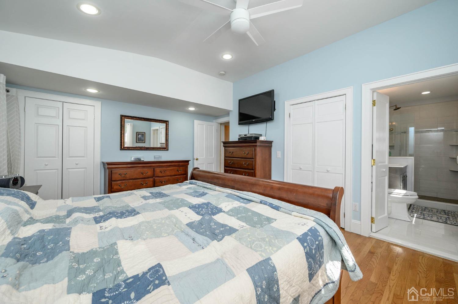 1221 Beech Avenue Mountainside, NJ 07092 - Photo 23 of 46 a bedroom with a large bed a flat tv screen and a chandelier