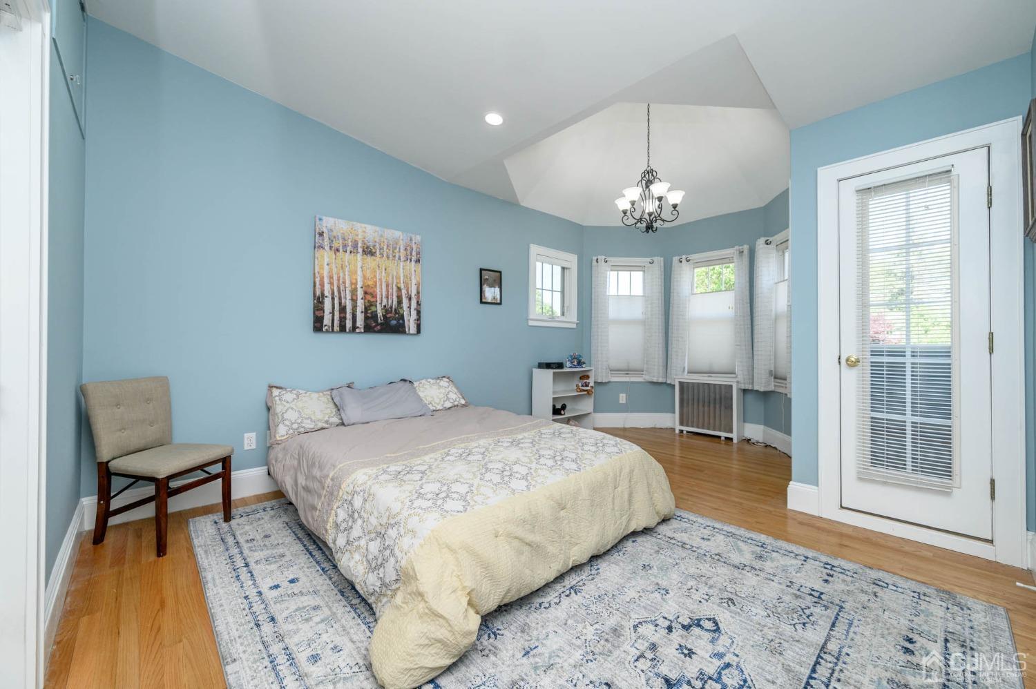 1221 Beech Avenue Mountainside, NJ 07092 - Photo 25 of 46 a spacious bedroom with a bed a chandelier and a window