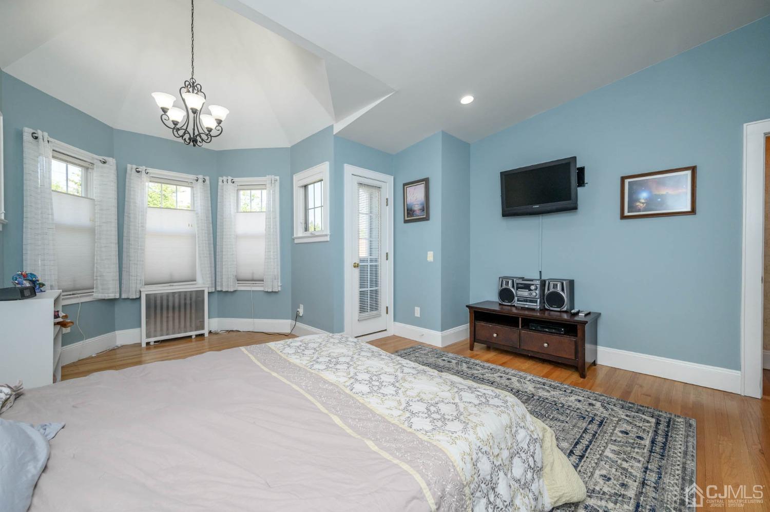 1221 Beech Avenue Mountainside, NJ 07092 - Photo 26 of 46 a bedroom with a bed and a chandelier