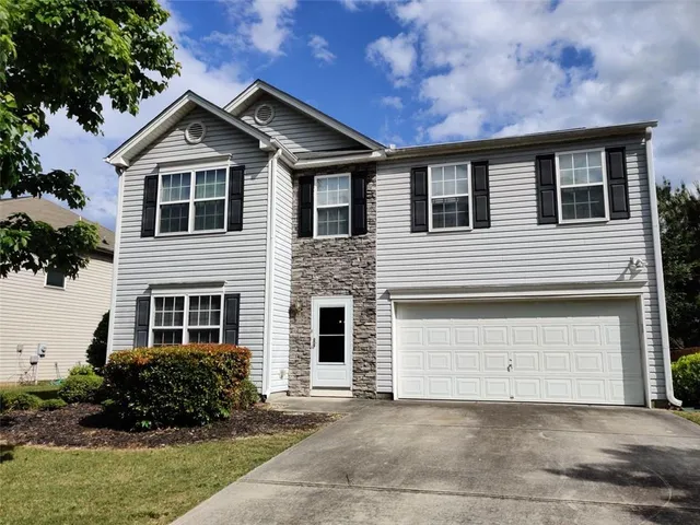 a front view of a house with a garden