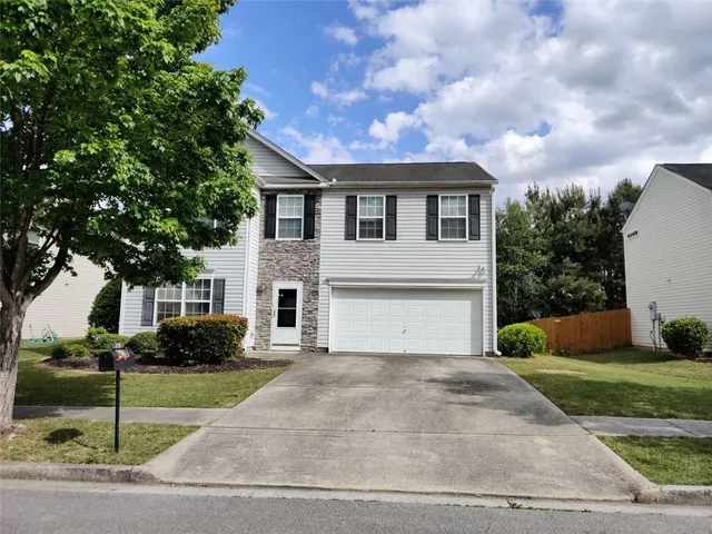 a front view of a house with a yard and garage