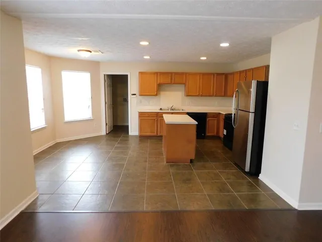 a view of kitchen with stainless steel appliances granite countertop a sink and a refrigerator