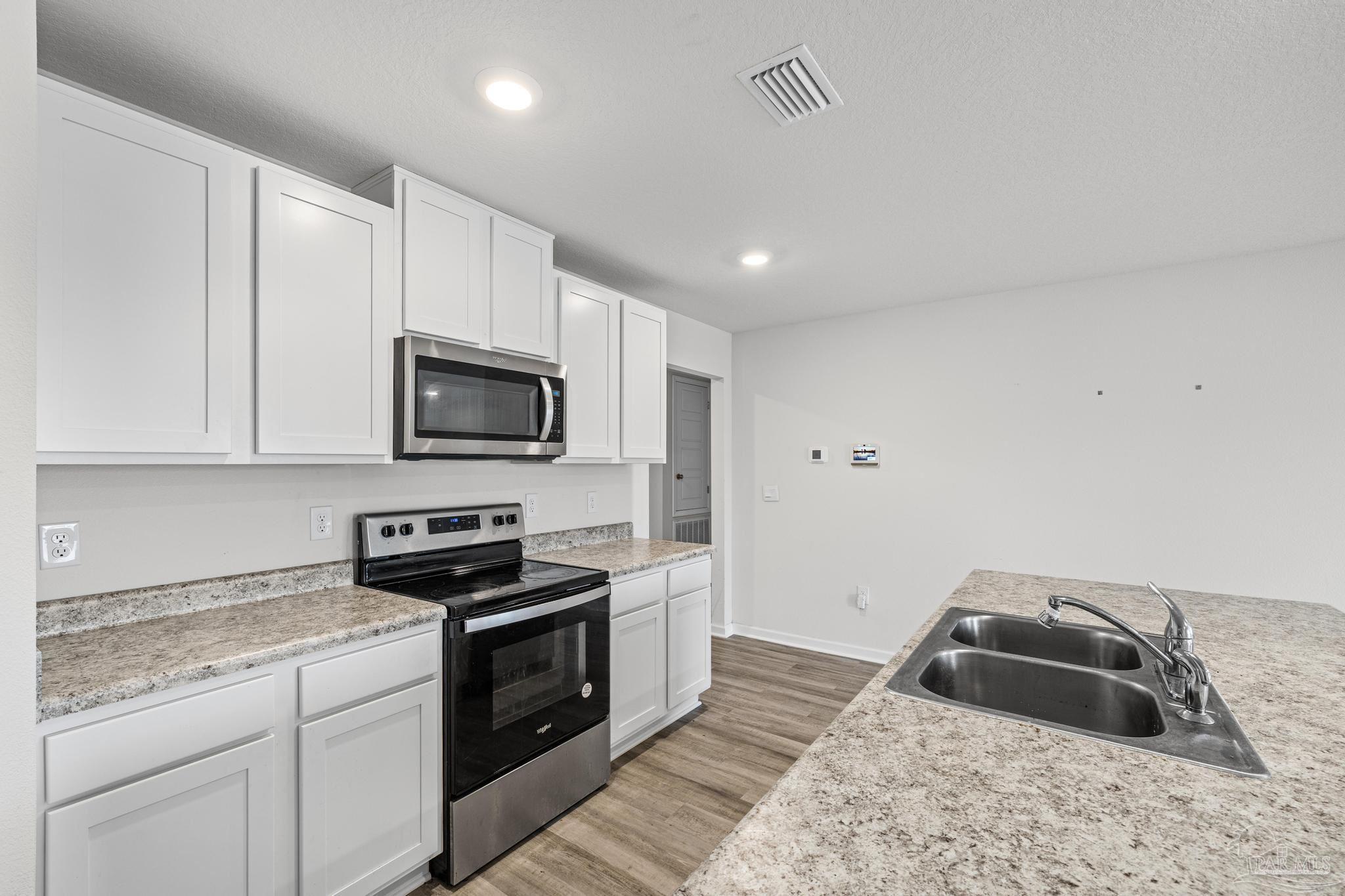 5771 Belmont Stakes Road Pensacola, FL 32526 - Photo 12 of 36 a kitchen with granite countertop a sink and a stove top oven
