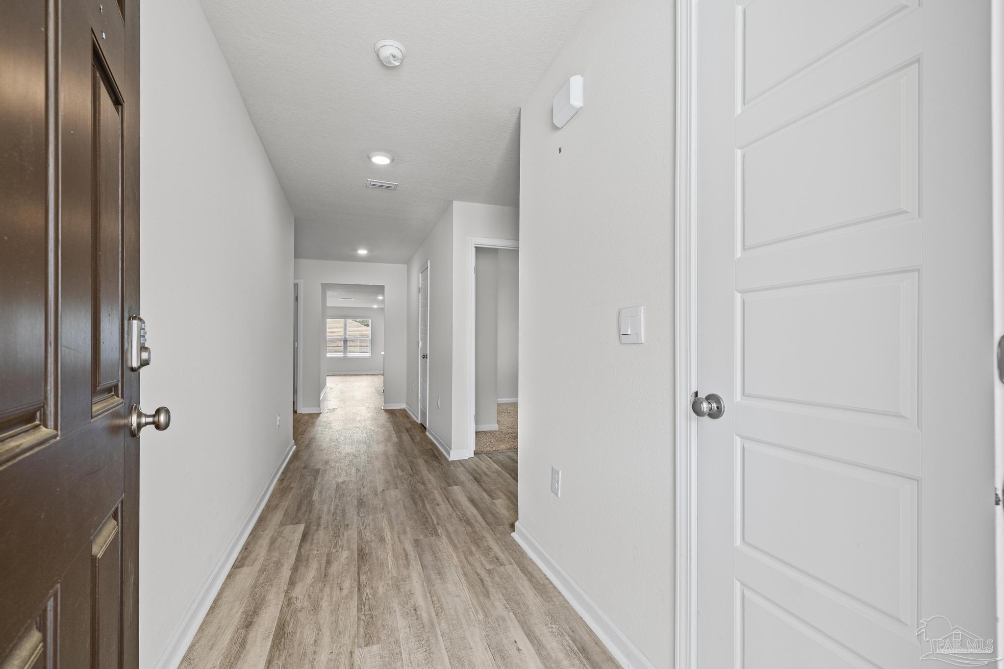5771 Belmont Stakes Road Pensacola, FL 32526 - Photo 16 of 36 a view of a hallway with wooden floor and a glass door
