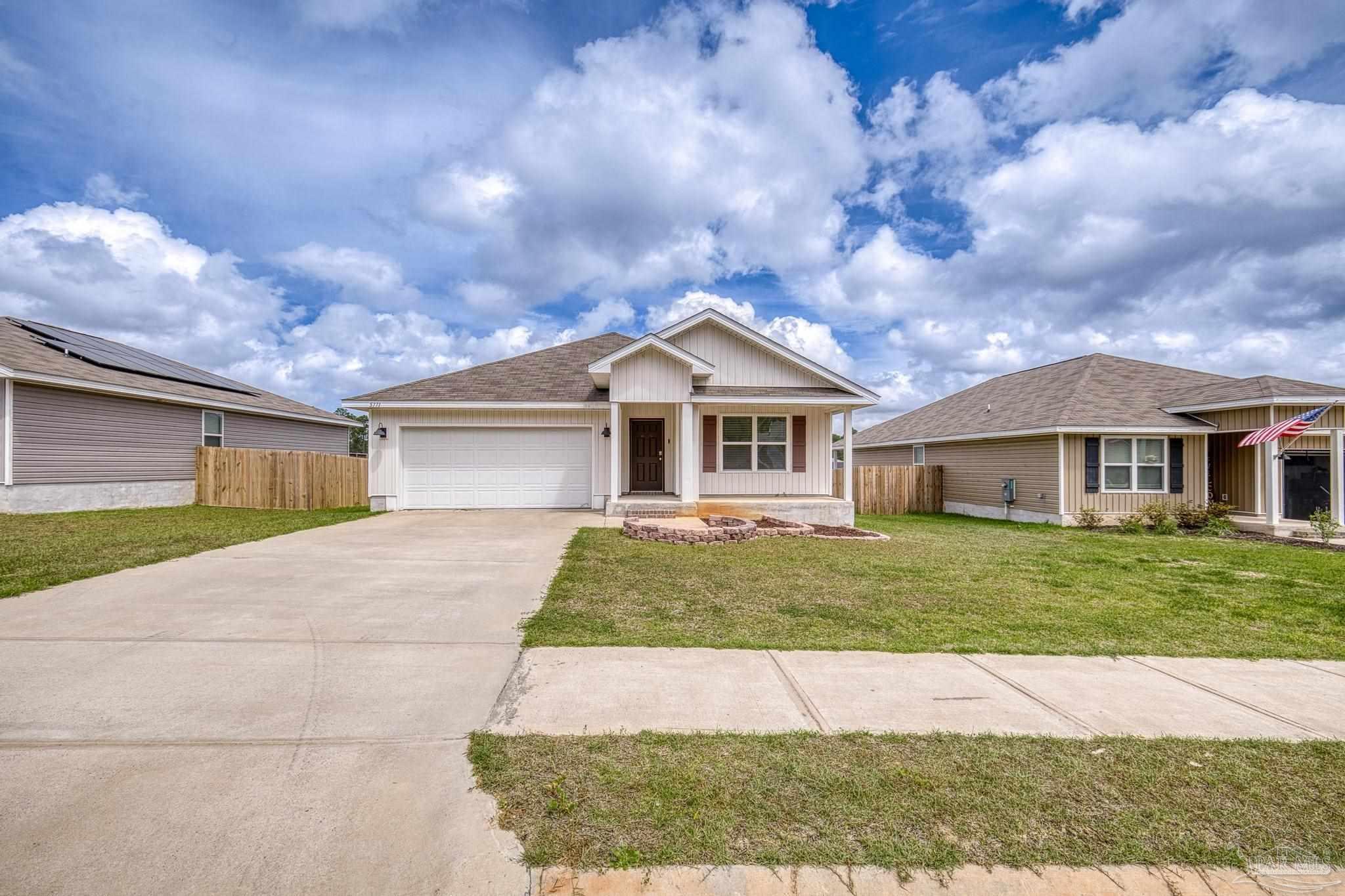 5771 Belmont Stakes Road Pensacola, FL 32526 - Photo 29 of 36 a front view of a house with a yard and garage