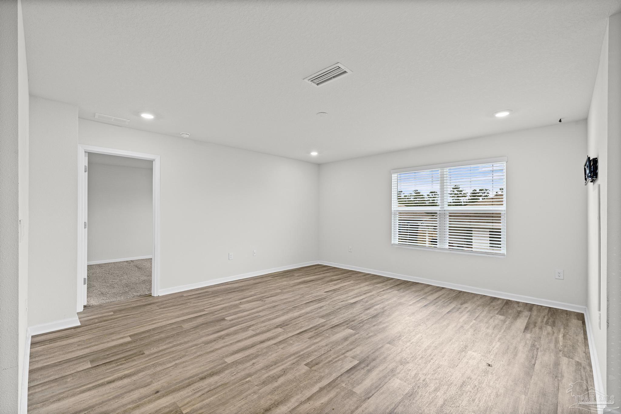 5771 Belmont Stakes Road Pensacola, FL 32526 - Photo 4 of 36 a view of an empty room with wooden floor and a window