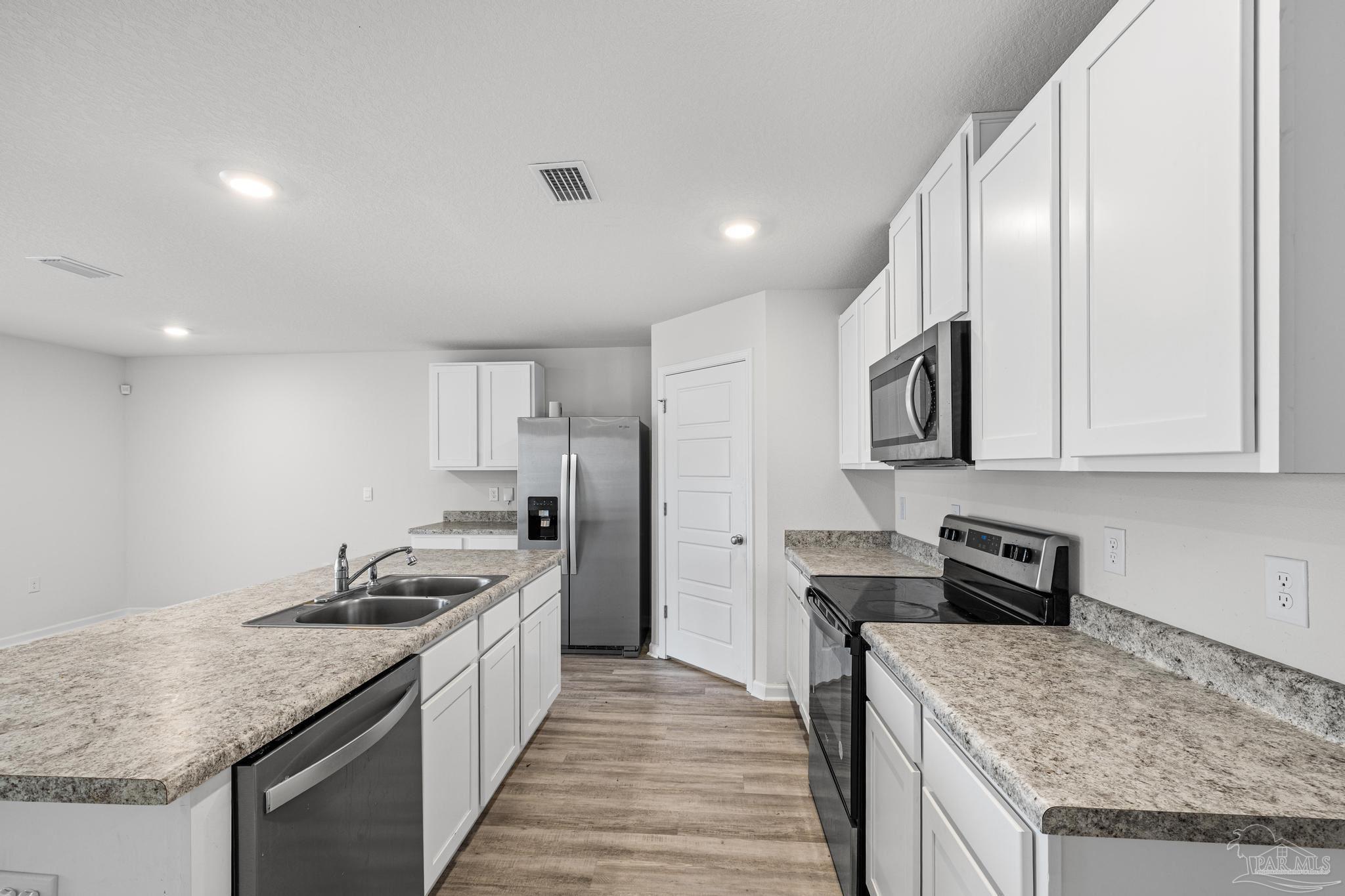 5771 Belmont Stakes Road Pensacola, FL 32526 - Photo 9 of 36 a kitchen with stainless steel appliances granite countertop a sink stove and refrigerator