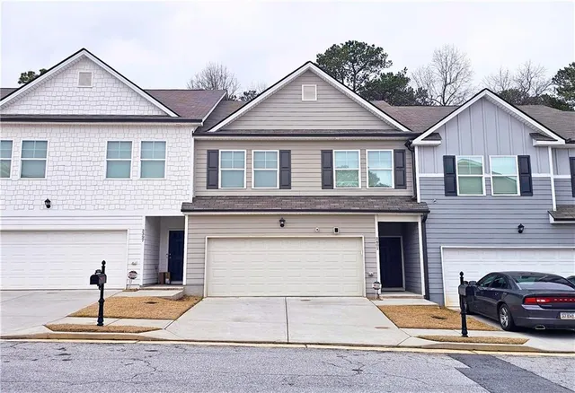 a front view of a house with parking area and garage