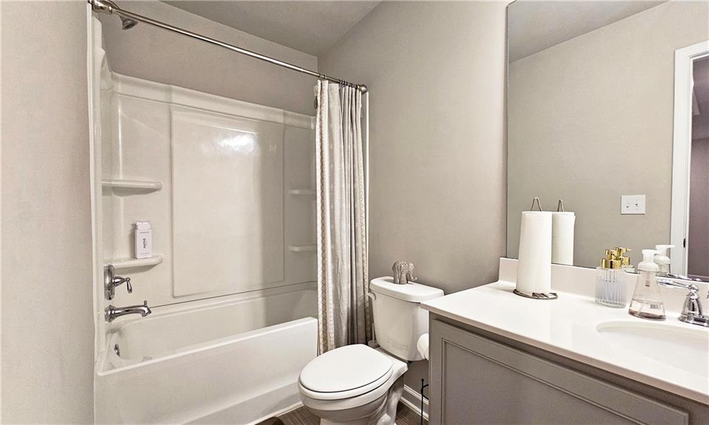 3401 Endurance Court, Unit 10 Atlanta, GA 30349 - Photo 14 of 17 a bathroom with a sink a toilet a mirror and a shower