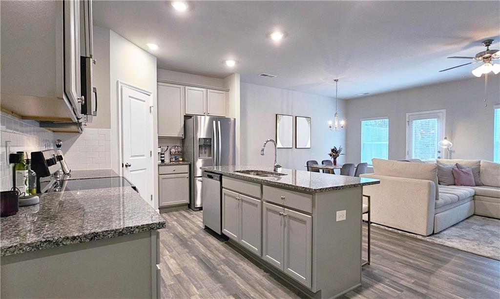 3401 Endurance Court, Unit 10 Atlanta, GA 30349 - Photo 3 of 17 a kitchen with stainless steel appliances granite countertop a refrigerator a stove and a sink