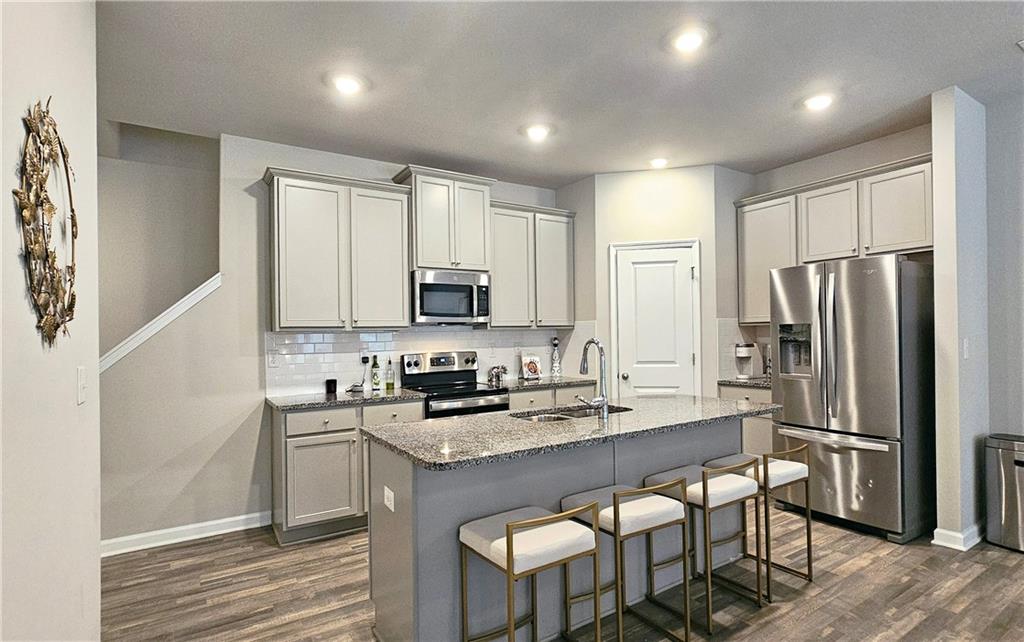 3401 Endurance Court, Unit 10 Atlanta, GA 30349 - Photo 4 of 17 a kitchen with stainless steel appliances a sink a stove a refrigerator cabinets and a dining table