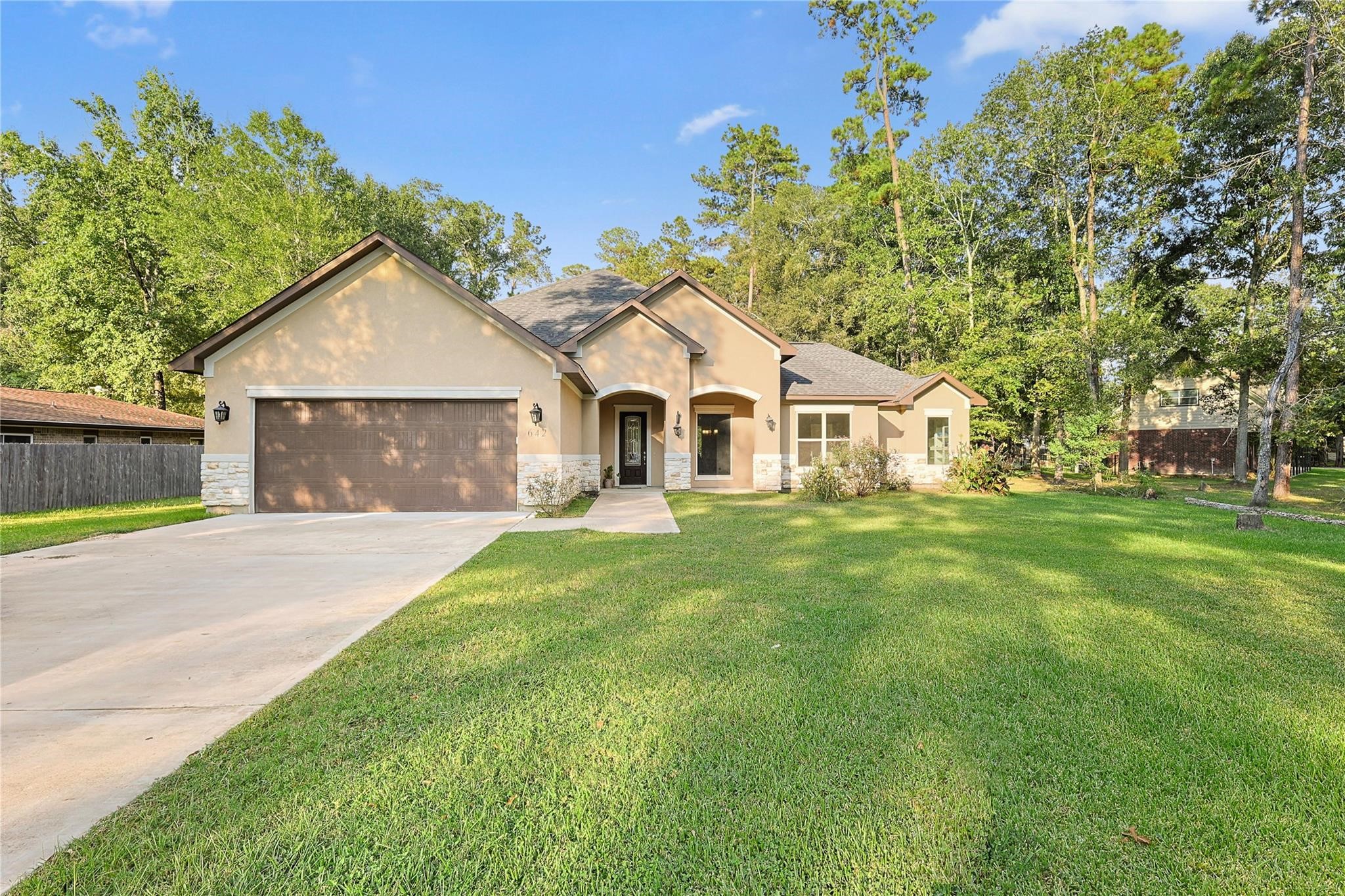 642 Parthenon Place New Caney, TX 77357 - Photo 1 of 30 a front view of a house with a garden and yard