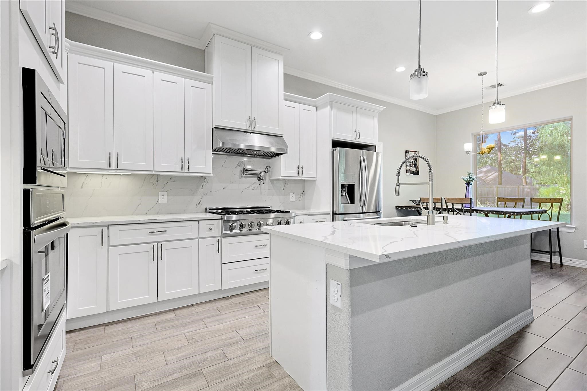 642 Parthenon Place New Caney, TX 77357 - Photo 6 of 30 a kitchen with kitchen island granite countertop a sink appliances cabinets and a counter top space