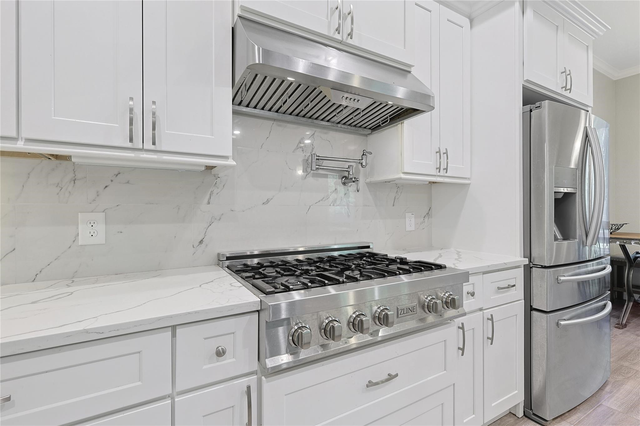 642 Parthenon Place New Caney, TX 77357 - Photo 7 of 30 a kitchen with stainless steel appliances granite countertop a refrigerator a stove and white cabinets