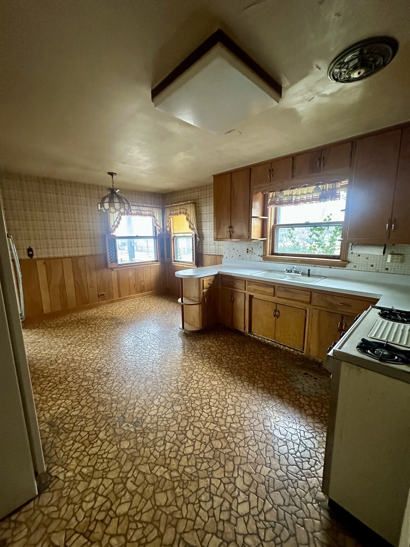 7000 West Henderson Street Chicago, IL 60634 - Photo 14 of 30 a kitchen with stainless steel appliances granite countertop a sink stove and cabinets