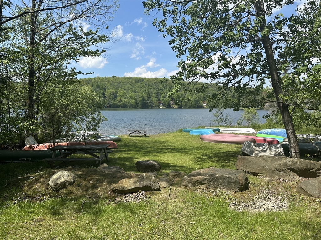 102 Wells Road Becket, MA 01223 - Photo 39 of 40 a view of a lake with a yard and large trees