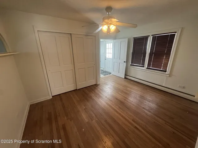 an empty room with wooden floor and window