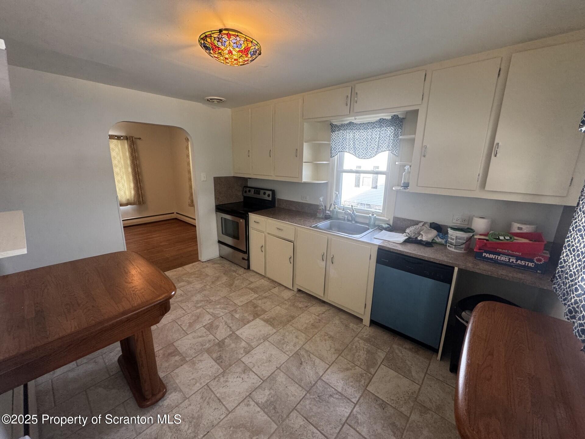910 Bernard Avenue Clarks Summit, PA 18411 - Photo 5 of 17 a kitchen with granite countertop a stove a sink dishwasher and a microwave oven with cabinets