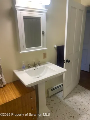 a bathroom with a sink a toilet and mirror
