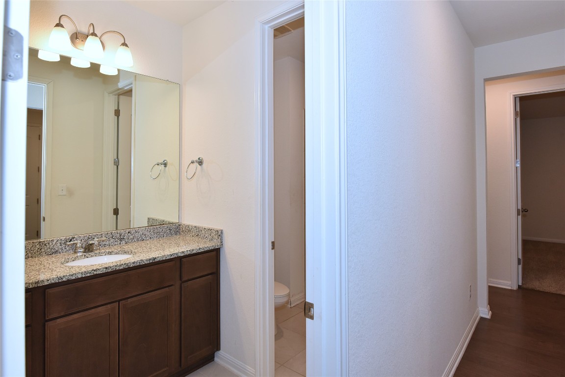 5008 Risana Bend Round Rock, TX 78665 - Photo 14 of 21 a bathroom with a granite countertop sink and a mirror