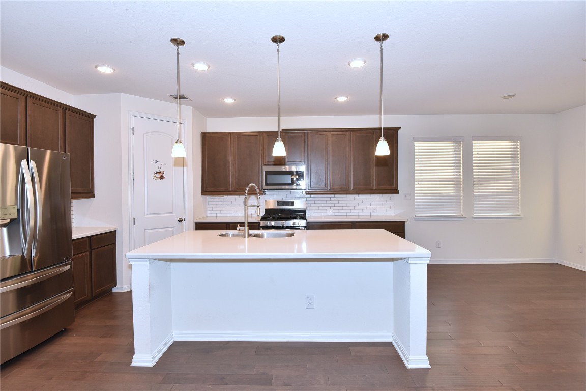 5008 Risana Bend Round Rock, TX 78665 - Photo 7 of 21 a large kitchen with a large counter top a refrigerator and a sink