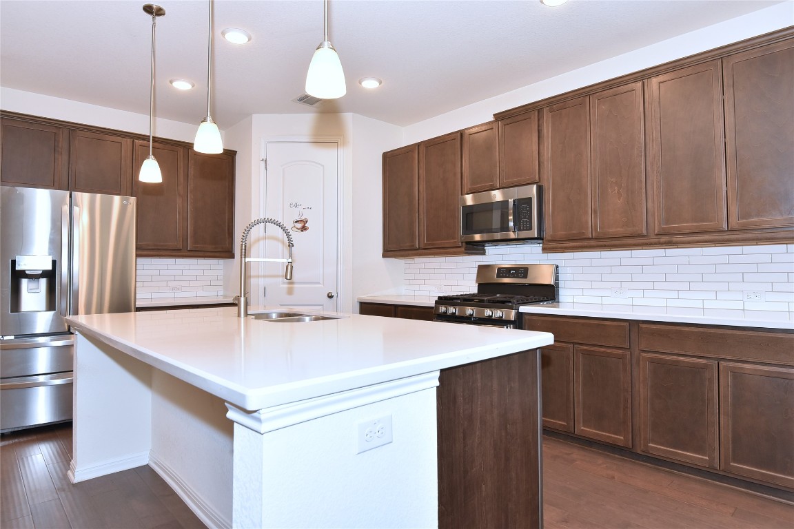 5008 Risana Bend Round Rock, TX 78665 - Photo 8 of 21 a kitchen with a sink a stove a refrigerator and cabinets
