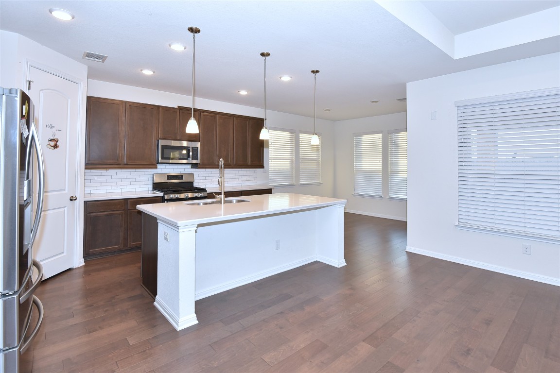 5008 Risana Bend Round Rock, TX 78665 - Photo 9 of 21 a kitchen with kitchen island a sink stainless steel appliances and cabinets