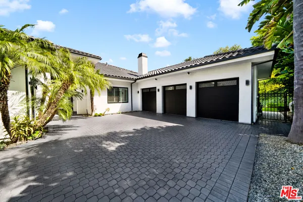 a view of a house with a yard and potted plants