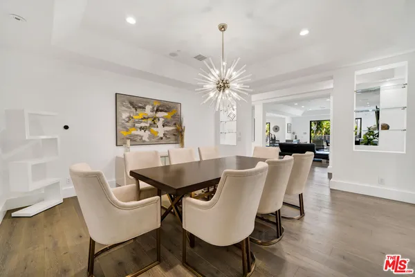 a view of a dining room with furniture wooden floor and chandelier