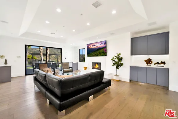 a living room with furniture a flat screen tv and a large window