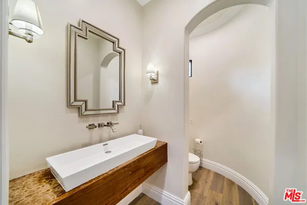 a bathroom with a sink a toilet and a mirror