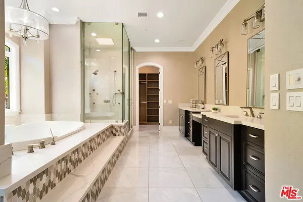 a large bathroom with a double vanity sink a large mirror and a bathtub