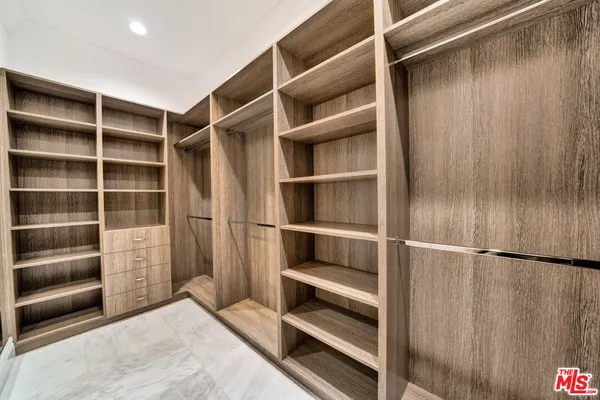 a view of walk in closet with empty racks