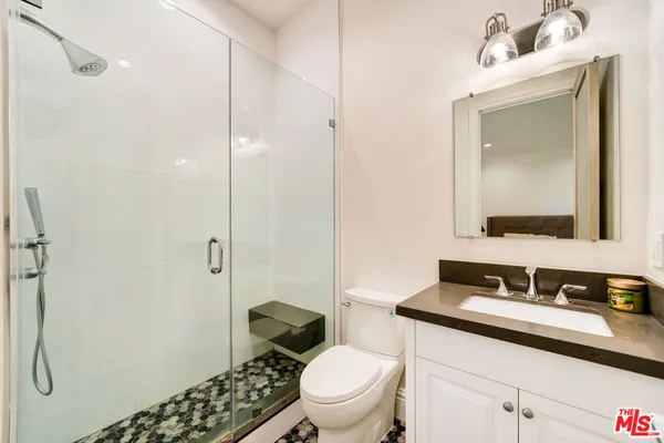 a bathroom with a granite countertop sink toilet and shower