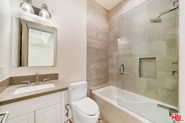 a bathroom with a sink vanity mirror and toilet