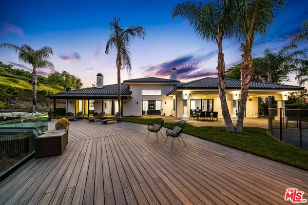 a view of a house with swimming pool and sitting area