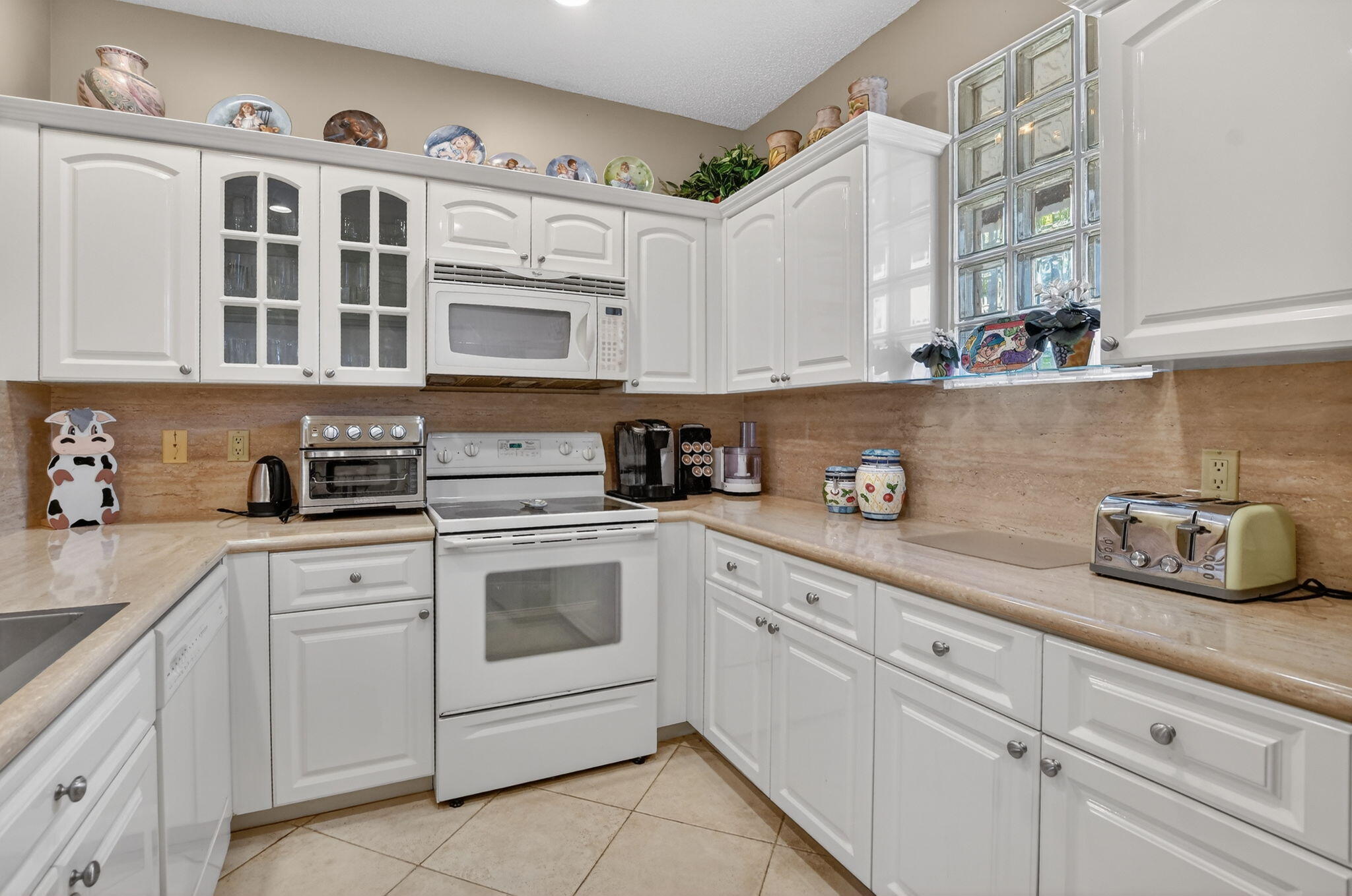 20220 Boca W Drive, Unit 702 Boca Raton, FL 33434 - Photo 11 of 51 a kitchen with cabinets appliances and a sink