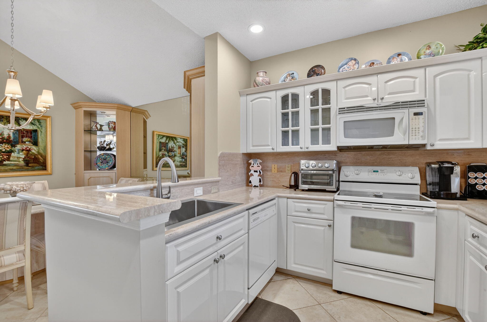20220 Boca W Drive, Unit 702 Boca Raton, FL 33434 - Photo 12 of 51 a kitchen with cabinets appliances a sink and a counter top space