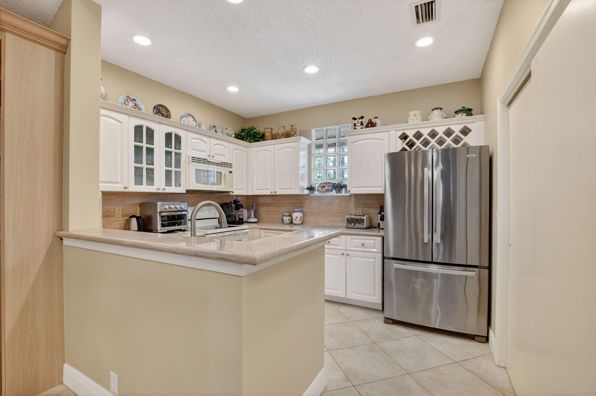 20220 Boca W Drive, Unit 702 Boca Raton, FL 33434 - Photo 10 of 51 a kitchen with stainless steel appliances granite countertop a refrigerator and a sink