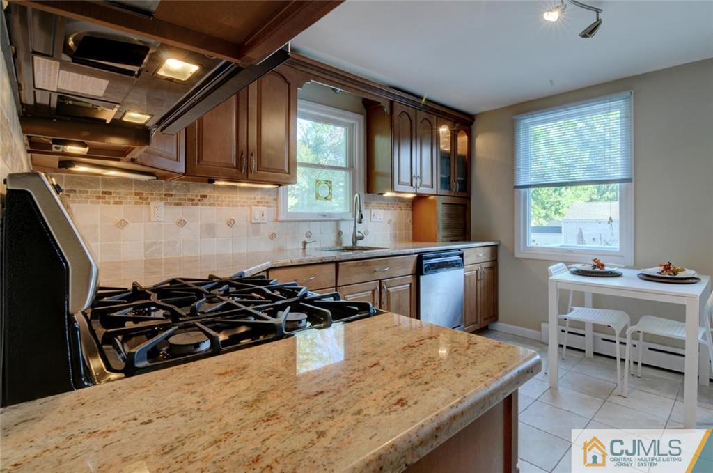 194 East Cliff Road Colonia, NJ 07067 - Photo 10 of 22 a kitchen with stainless steel appliances granite countertop a sink a stove and a wooden cabinets