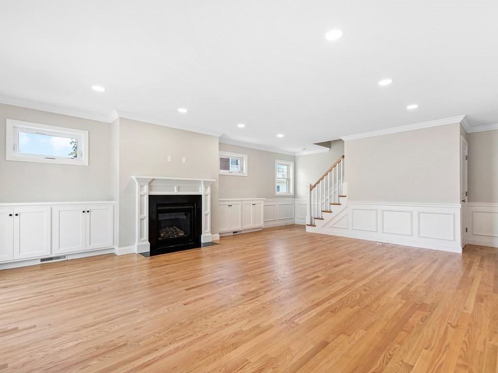 125 Thornton Road Waltham, MA 02453 - Photo 15 of 42 a view of empty room with wooden floor and fireplace