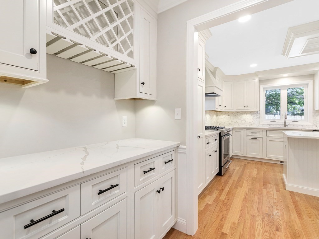 125 Thornton Road Waltham, MA 02453 - Photo 9 of 42 a kitchen with cabinets oven and a dishwasher with wooden floor