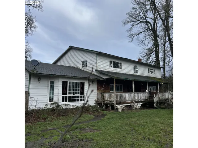 a view of a house with backyard and sitting area