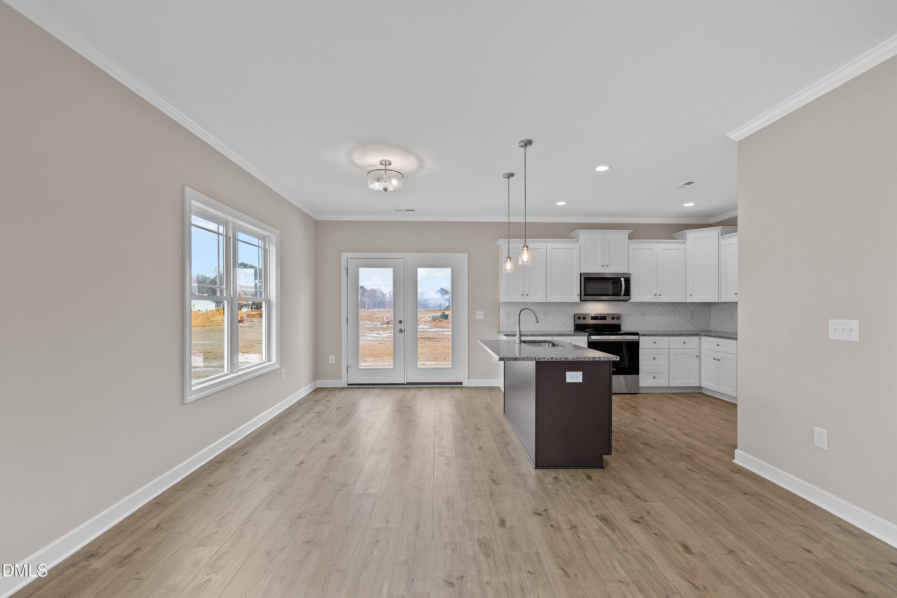 926 Micro Road West Selma, NC 27576 - Photo 15 of 41 a kitchen with stainless steel appliances kitchen island wooden cabinets and stove top oven
