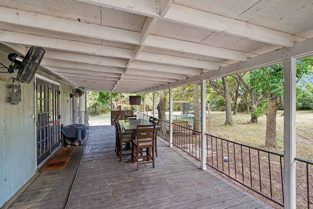 6356 Rendon Bloodworth Road Fort Worth, TX 76140 - Photo 8 of 25 Expansive covered porch featuring a wood-finish floor, white exposed beam ceiling, and a black metal railing