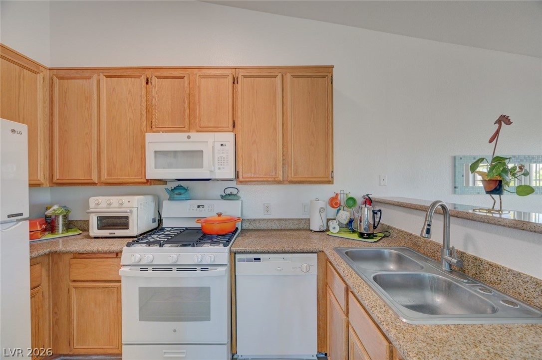 3318 North Decatur Boulevard, Unit 2072 Las Vegas, NV 89130 - Photo 12 of 50 A well-appointed kitchen showcasing light wood cabinetry and functional appliances.