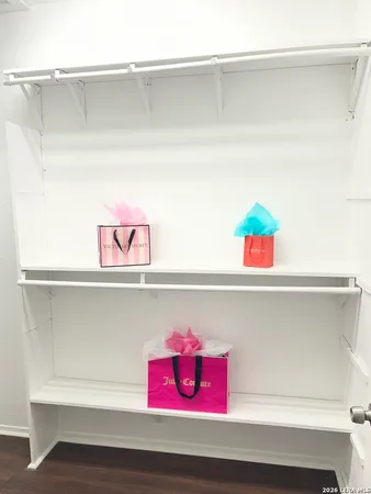 a utility room with closet and wooden floor