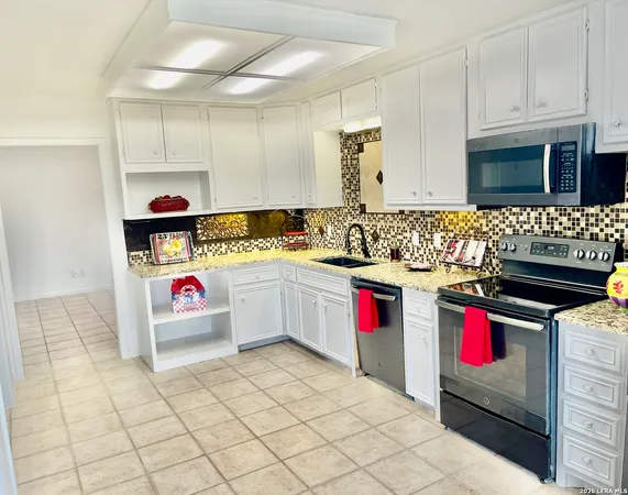 a kitchen with stainless steel appliances granite countertop a sink and a stove