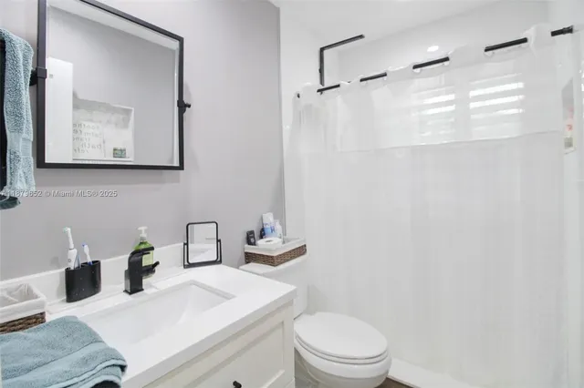 a bathroom with a sink mirror vanity and toilet